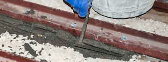 Remplissage entre la poutrelle et la pièce métallique de renfort, avec mortier de ciment, industriel, avec adjuvant hydrofuge, M-15